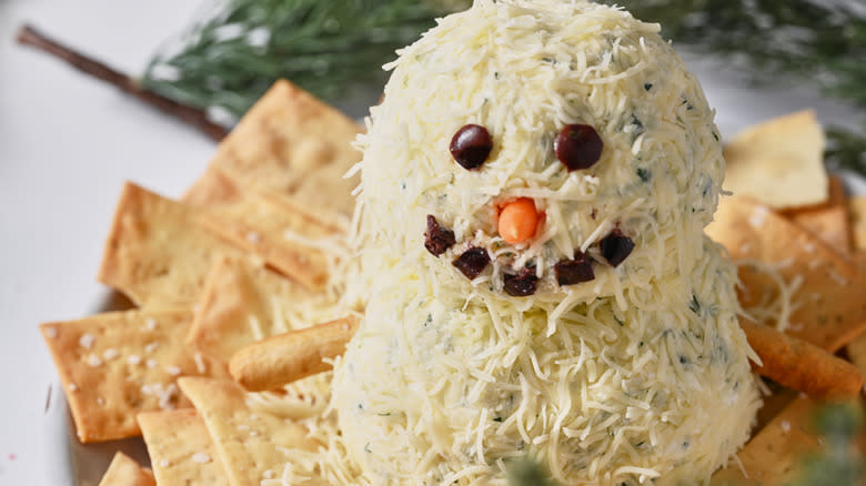 snowman cheese ball on plate with crackers