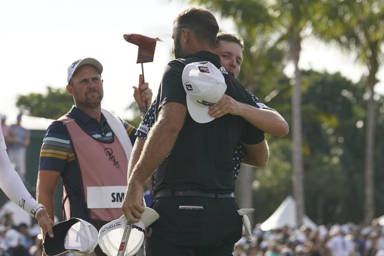 Cameron Smith, right, hugs Dustin Johnson after the final round of the LIV Golf Team Championship at Trump National Doral Golf Club, Sunday, Oct. 30, 2022, in Doral, Fla. Johnson's 4 Aces GC team won the team championship. (AP Photo/Lynne Sladky)