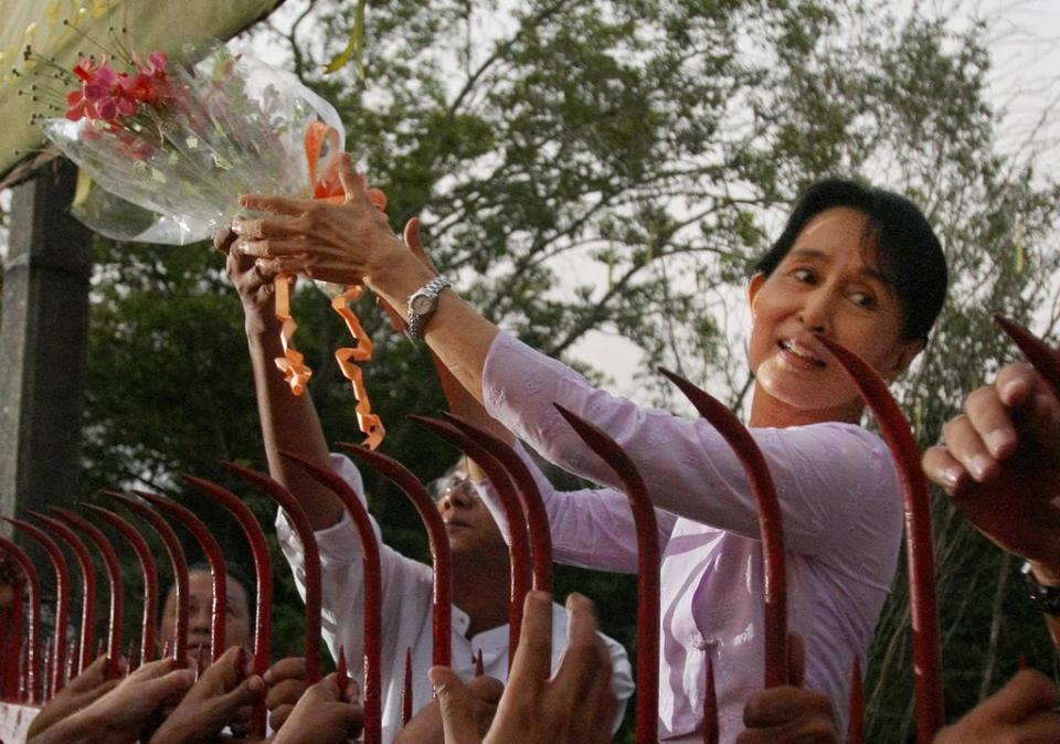 La líder de la oposición Aung San Suu Kyi saluda a sus partidarios tras su liberación en Yangon el 13 de noviembre de 2010 (AFP via Getty Images)