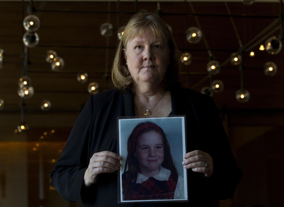 Becky Ianni, a victim of priest abuse, poses for a portrait with a picture of her younger self, during the United States Conference of Catholic Bishops 2019 Spring meetings in Baltimore, Tuesday, June 11, 2019. Ianni was 8-years-old when she says the priest of her family parish began to abuse her. (AP Photo/Jose Luis Magana)
