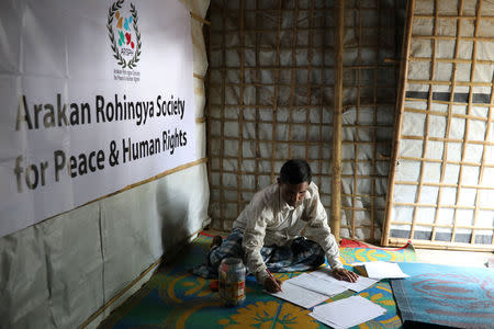 Mohib Bullah, a member of Arakan Rohingya Society for Peace and Human Rights, writes after collecting data about victims of a military crackdown in Myanmar, at Kutupalong camp in Cox's Bazar, Bangladesh, April 21, 2018. Picture taken April 21, 2018. REUTERS/Mohammad Ponir Hossain