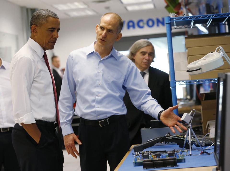 U.S. President Barack Obama (L) listens to engineer Rod Washington as he tours Vacon, a company that manufactures AC drives, during a visit to Raleigh, North Carolina, in this January 15, 2014 file photo. At right is Energy Secretary Ernest Moniz. As Washington tightened its belt in recent years, the budget cuts sliced more deeply in states where President Obama is unpopular, according to a federal spending analysis by Reuters. Between the 2009 and 2013 fiscal years, funding for a wide swath of discretionary grant programs, from Head Start preschool education to anti drug initiatives, fell by an average of 40 percent in Republican-leaning states like Texas and Mississippi. To match Exclusive USA-POLITICS/SPENDING REUTERS/Kevin Lamarque/Files (UNITED STATES - Tags: POLITICS BUSINESS)