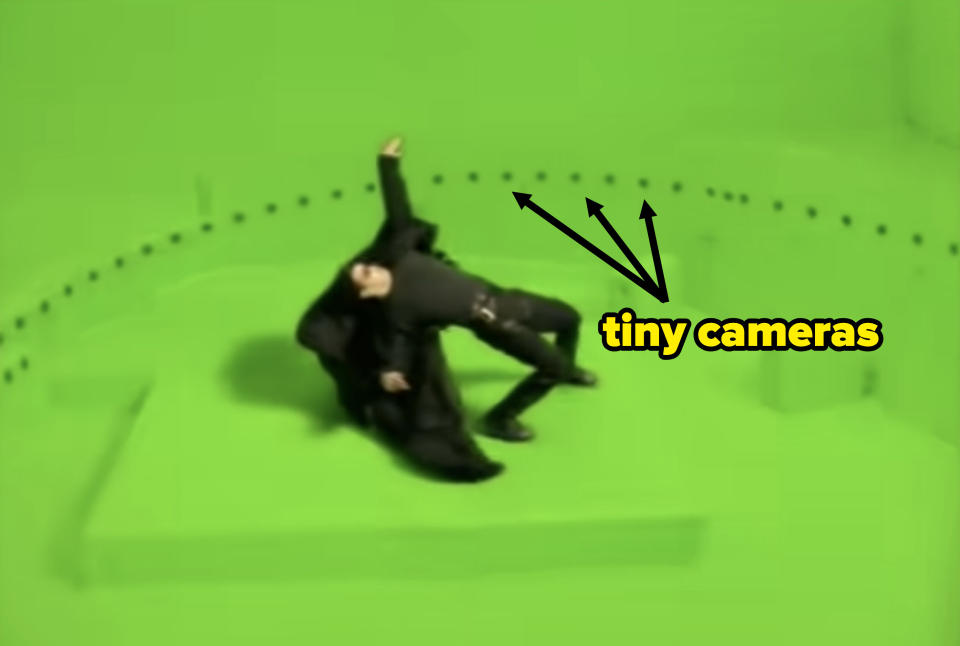 keanu leaning back with arrows pointing to the tiny cameras surrounding him