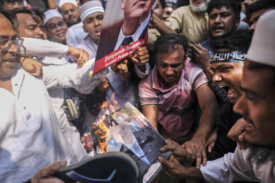 Muslims burn a portrait of Israeli Prime Minister Benjamin Netanyahu during a protest against Israel's military operations in Gaza and to support the Palestinian people, in front of Baitul Mukarram mosque in Dhaka, Bangladesh, Friday, Oct. 13, 2023. (AP Photo/Mahmud Hossain Opu)