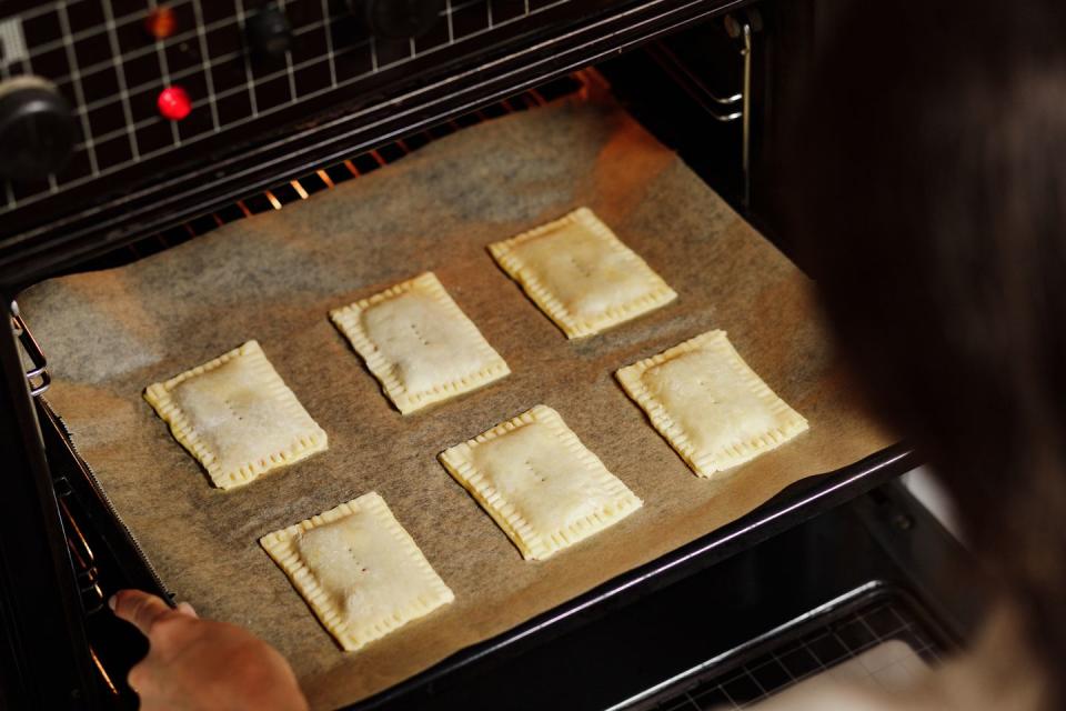 woman baking toaster pastry in oven