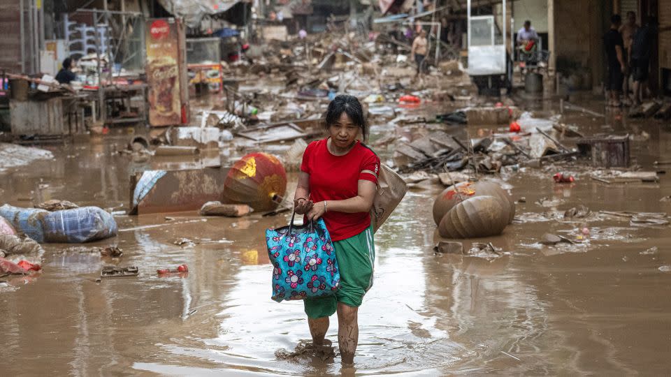 Una mujer camina por las calles devastadas de Meizhou, provincia de Guangzhou, el 19 de junio. - John Ricky/Anadolu/Getty Images