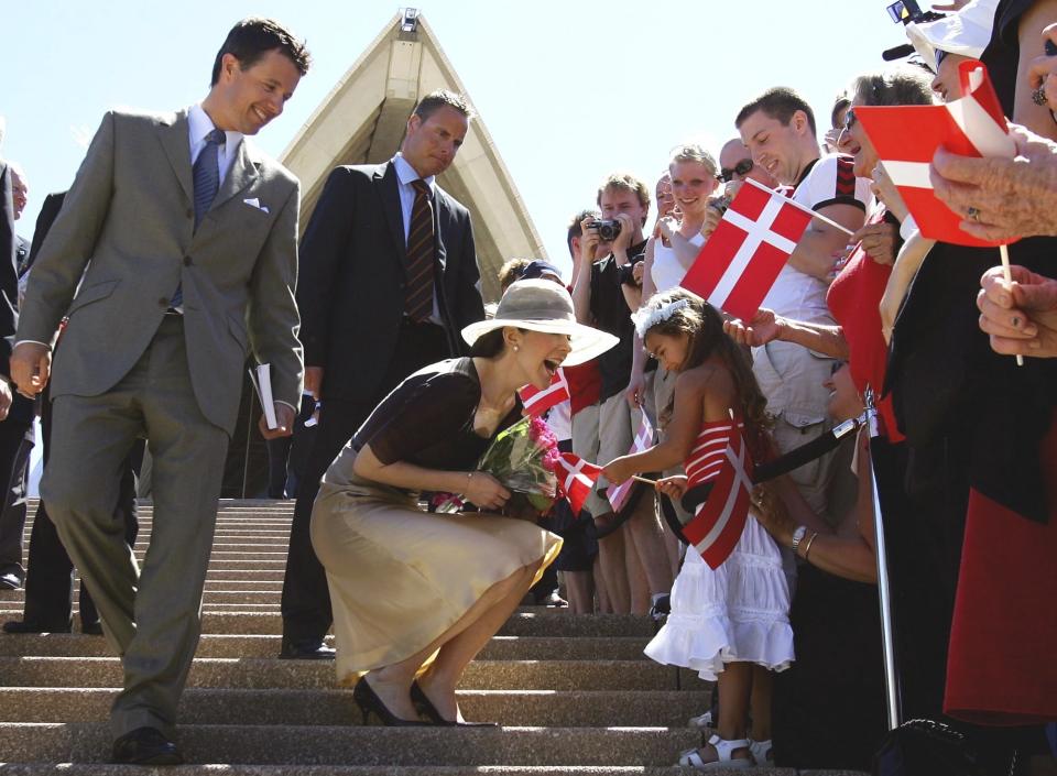 FILE - Denmark's Crown Prince Frederik, left, and his wife Princess Mary greet Mia Formica, 4, on the steps of the Sydney Opera House in Sydney on Monday March 7, 2005. As a teenager, Crown Prince Frederik felt uncomfortable being in the spotlight, and pondered whether there was any way he could avoid becoming king. All doubts have been swept aside as the 55-year-old takes over the crown on Sunday, Jan. 14, 2024 from his mother, Queen Margrethe II, who is breaking with centuries of Danish royal tradition and retiring after a 52-year reign. (David Gray, Pool Photo via AP, File)