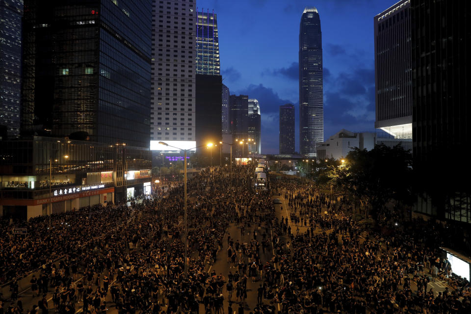 In this Sunday, June 16, 2019, photo, protesters wearing black t-shirts gather on a main road near the Legislative Council as they continuing protest against the unpopular extradition bill in Hong Kong. The largely youth-driven movement challenging Hong Kong's government over an unpopular extradition law is a coalition operating without a clear leadership structure. And that adds to its appeal for supporters disaffected from the moneyed elites who run the former British colony, organizers say. (AP Photo/Kin Cheung)