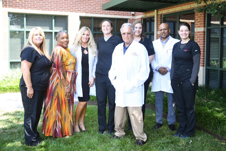 Dr. John McElligott poses for a photo outside his office with his staff, Friday, July 15, 2022. McElligott is receiving the Health Care Heroes Lifetime Achievement award. 