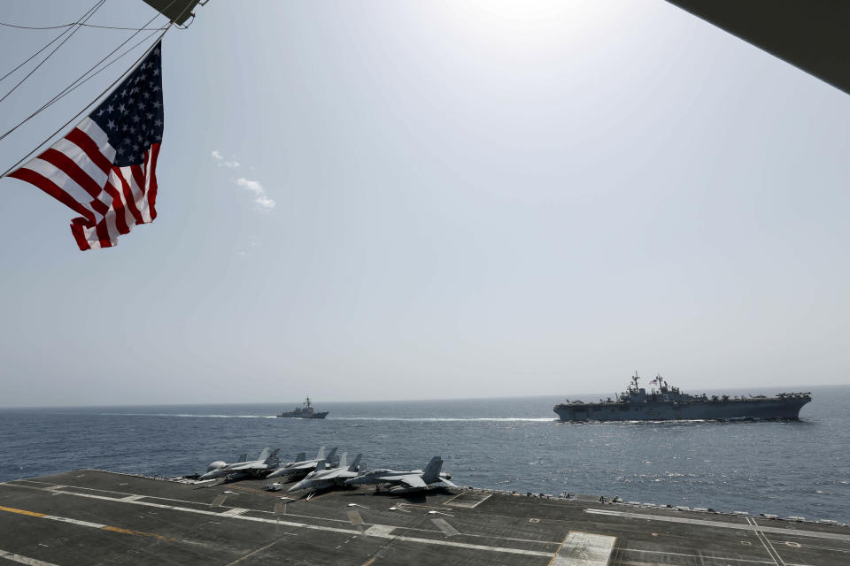 CORRECTS DATE - In this Friday, May 17, 2019, photo, released by the U.S. Navy, the amphibious assault ship USS Kearsarge, right, and the Arleigh Burke-class guided-missile destroyer USS Bainbridge, left, are seen from the Nimitz-class aircraft carrier USS Abraham Lincoln as they sail in the Arabian Sea. Commercial airliners flying over the Persian Gulf risk being targeted by "miscalculation or misidentification" from the Iranian military amid heightened tensions between the Islamic Republic and the U.S., American diplomats warned Saturday, May 18, 2019, even as both Washington and Tehran say they don't seek war. (Mass Communication Specialist Seaman Michael Singley, U.S. Navy via AP)