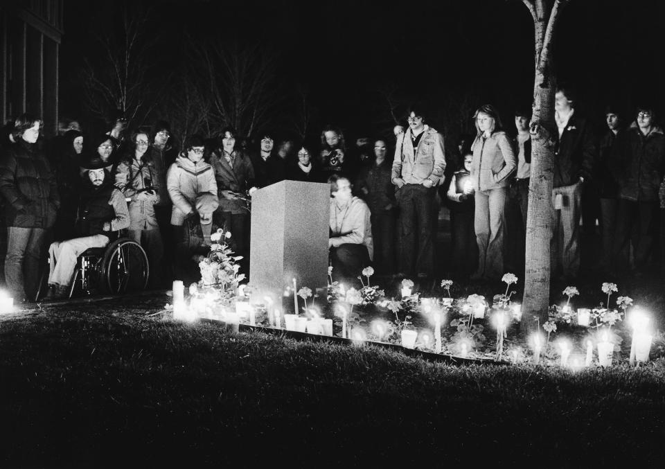 Candles from the annual commemoration May 3, 1978, light a ring around the memorial marker for the four students killed May 4, 1970, at Kent State University. Taylor Hall can be seen in the background at left.