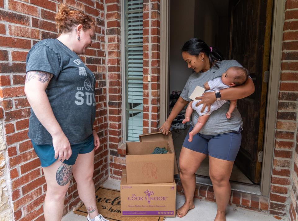 Inten Utari and her baby, Nadia, greet Alicia Fischweicher, Farmshare Austin's food access director, at their door while receiving a delivery. Utari and her daughter have been part of Ascension Seton Medical Center's pilot program Food is the Best Medicine, which sends nutritious items to new mothers identified as having food insecurity.