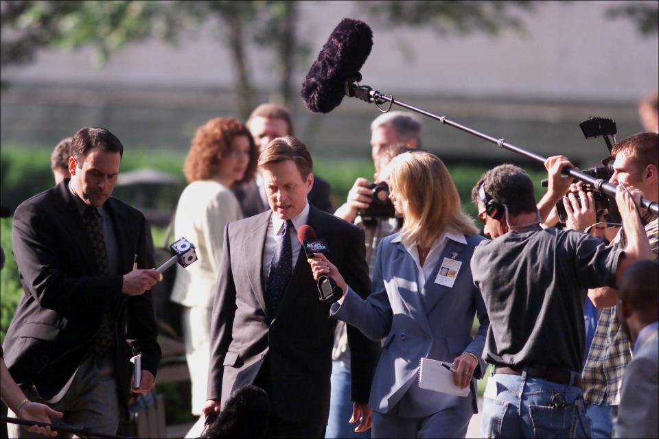 Real-life journalists Eric Collins, left, and Lorene Wagner go before the cameras as movie extras to interview actor Michael Douglas during filming of "Traffic" on the Statehouse grounds in 2000.