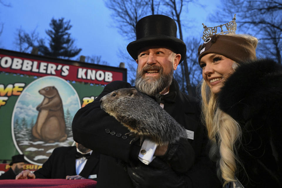 Groundhog Club handler A.J. Dereume holds Punxsutawney Phil, the weather prognosticating groundhog, while posing for a photo with Miss Pennsylvania Miranda Moore during the 138th celebration of Groundhog Day on Gobbler's Knob in Punxsutawney, Pa., Friday, Feb. 2, 2024. Phil's handlers said that the groundhog has forecast an early spring. (AP Photo/Barry Reeger)