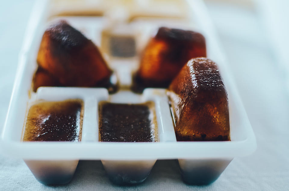 Tray with frozen coffee cubes in four compartments, two of the ice cube compartments are empty