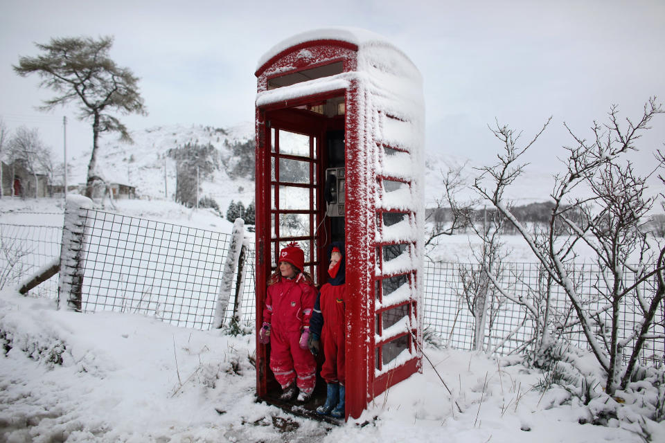 Snow day! Nina Padmanabhan and Murray Waugh shelter from the cold in a red telephone box following a sledging trip in Braemar, Scotland. Snow returned to the central belt of Scotland just a week after the country experienced record high temperatures for March.