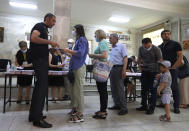 People at a polling station during a parliamentary election in Yerevan, Armenia, Sunday, June 20, 2021. Armenians are voting in a national election after months of tensions over last year's defeat in fighting against Azerbaijan over the separatist region of Nagorno-Karabakh. (AP Photo/Sergei Grits)