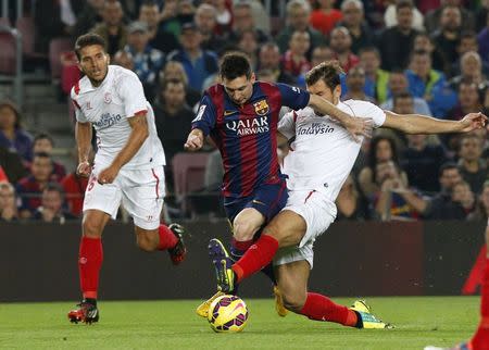 Barcelona's Lionel Messi (C) is challenged by Sevilla's Grzegorz Krychowiak during their Spanish first division soccer match at Nou Camp stadium in Barcelona November 22, 2014. REUTERS/Gustau Nacarino