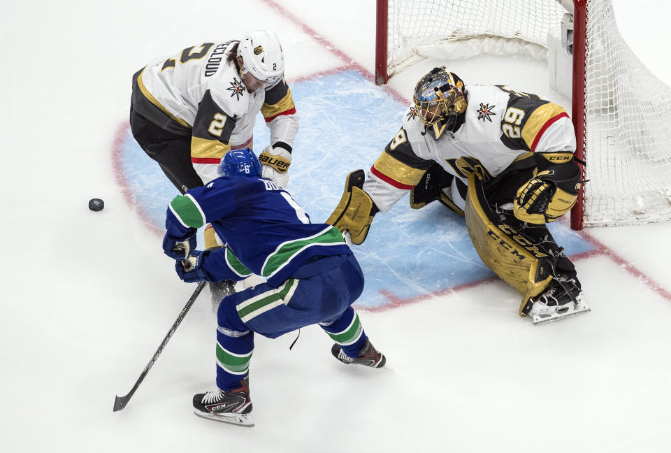 Vegas Golden Knights goalie Marc-Andre Fleury (29) makes the save as Vancouver Canucks' Brock Boeser (6) and Zach Whitecloud (2) battle for the rebound during the second period of an NHL Western Conference Stanley Cup playoff game, Sunday, Aug. 30, 2020, in Edmonton, Alberta. (Jason Franson/The Canadian Press via AP)