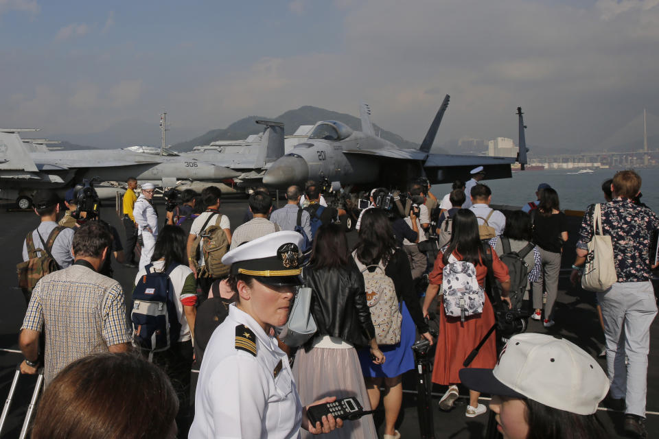 Journalists and navy sailors gather on the deck of the U.S. Navy USS Ronald Reagan aircraft carrier in Hong Kong, Wednesday, Nov. 21, 2018. The USS Reagan docked in Hong Kong on Wednesday, days after a pair of American B-52 bombers flew over the disputed South China Sea. (AP Photo/Kin Cheung)
