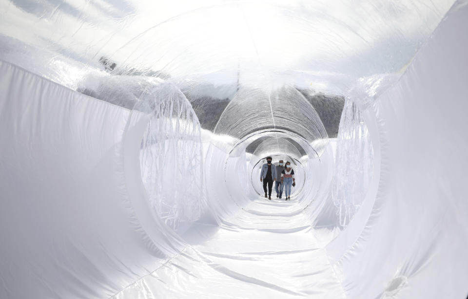 Designers walk through their Portable Epidemiological Insulation Unit during a media presentation, in Bogota, Colombia, Tuesday, Feb. 16, 2021. Colombia’s La Salle University school of architecture designed the small polyhedral pneumatic geodesic domes which can be used to isolate and treat COVID-19 patients in areas where there are no nearby hospitals or where existing hospitals are overwhelmed with patients. (AP Photo/Fernando Vergara)