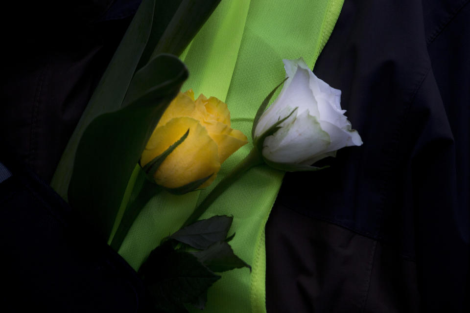 A demonstrators carries roses in his yellow vest during a peaceful demonstration in Amsterdam, Netherlands, Saturday, Dec. 8, 2018. The French yellow vest protest movement is crossing borders, with demonstrations planned in neighboring Belgium and in the Netherlands. Neither country has proposed a hike in fuel tax, the catalyst for the massive and destructive demonstrations in France in recent weeks. (AP Photo/Peter Dejong)