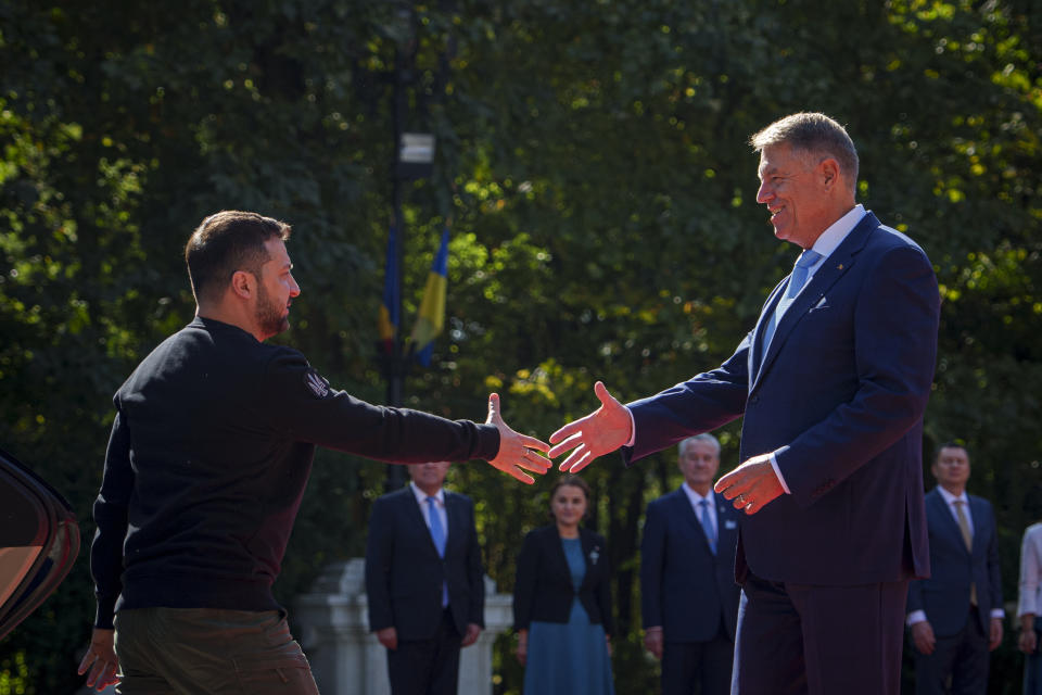 Ukraine's President Volodymyr Zelenskyy, left, prepares to shake hands with Romanian President Klaus Iohannis at the Cotroceni Presidential Palace in Bucharest, Romania, Tuesday, Oct. 10, 2023. (AP Photo/Andreea Alexandru)