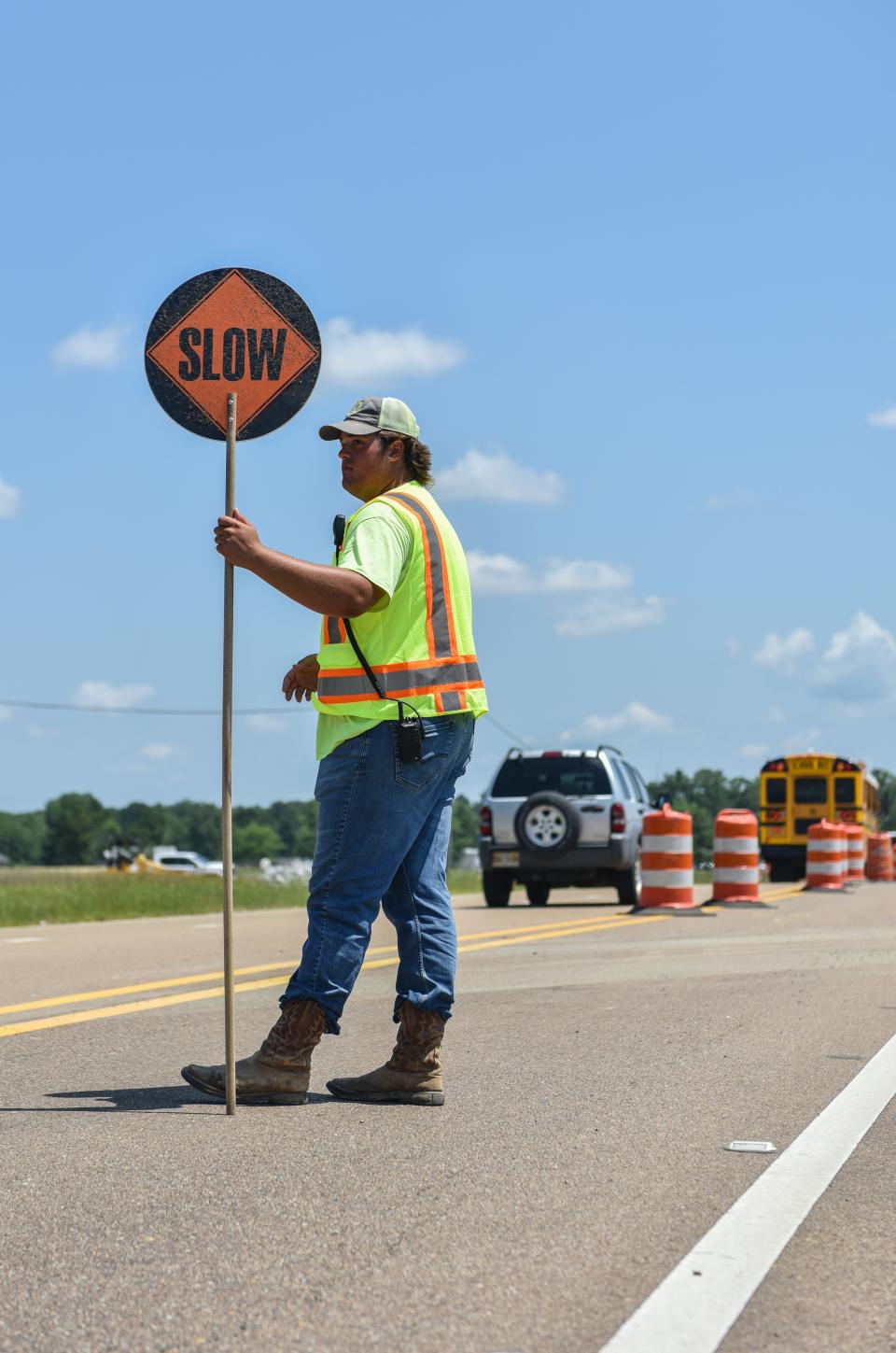 Landon Herbert, 21, directs traffic outside near a construction site for Southern Rock, LLC in the afternoon heat, Brandon, Miss., Tuesday, June 21, 2022. 