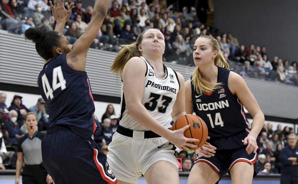Providence's Emily Archibald (33) squeezes past UConn's Aubrey Griffin (44) and Dorka Juhász (14) under the net during the second half of an NCAA college basketball game, Wednesday, Feb. 1, 2023, in Providence, R.I. (AP Photo/Mark Stockwell)