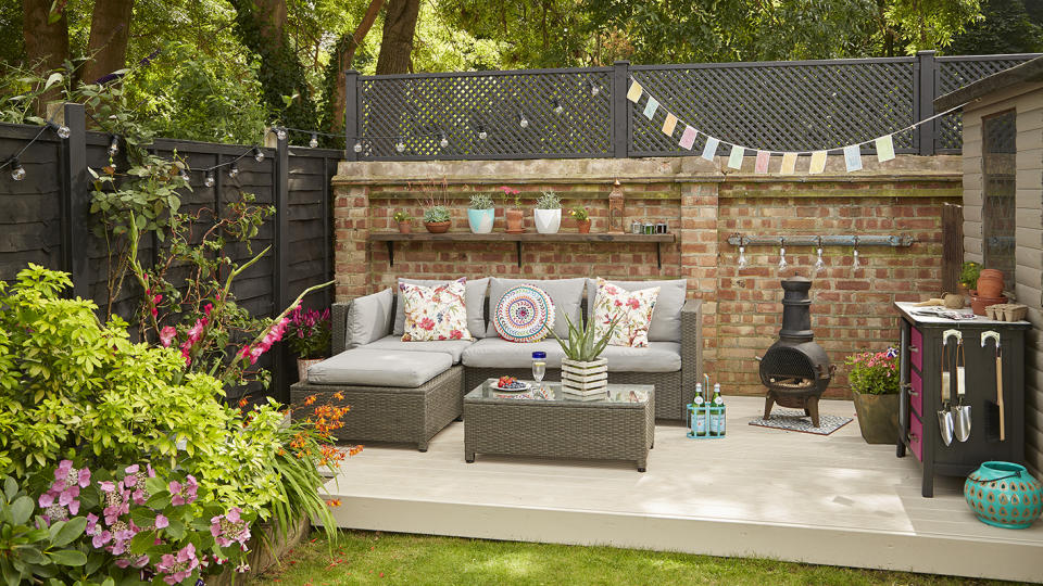 <p> If the bottom area of your garden is the place that gets the most sun, it&apos;s the ideal spot for&#xA0;outdoor living space ideas. As it&apos;s further away from the house, it also gives a feeling of seclusion and privacy.&#xA0; </p> <p> The decking gives the space a more permanent feel, as though it&apos;s an extension of the home, which is enhanced by the shelves on the rear wall. Add some bright bunting and color pop cushions for some fun and flair. </p>