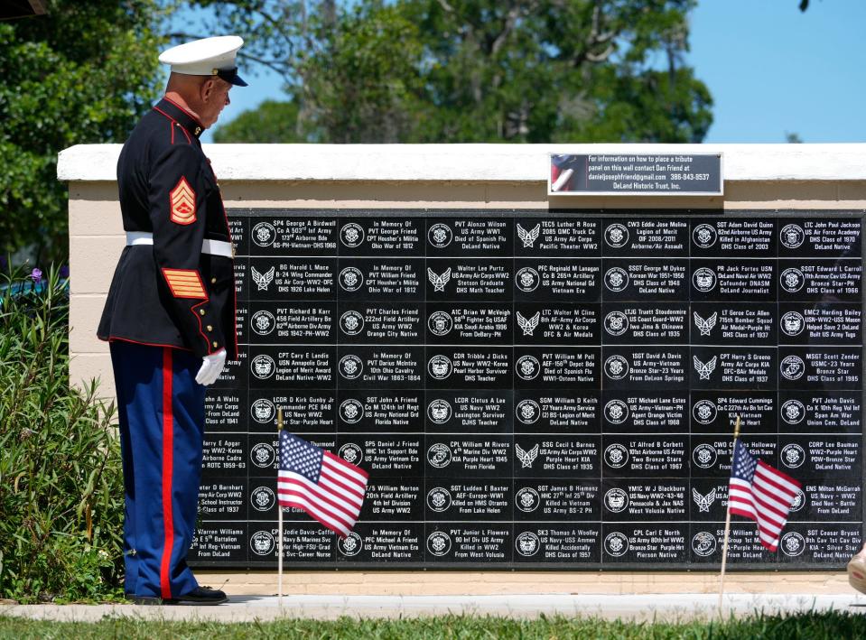 In this photo from 2022, a Marine stands at attention near a memorial at Bill Dreggors Park in DeLand for those killed in combat. Cities across Volusia and Flagler counties will commemorate veterans this Memorial Day weekend.