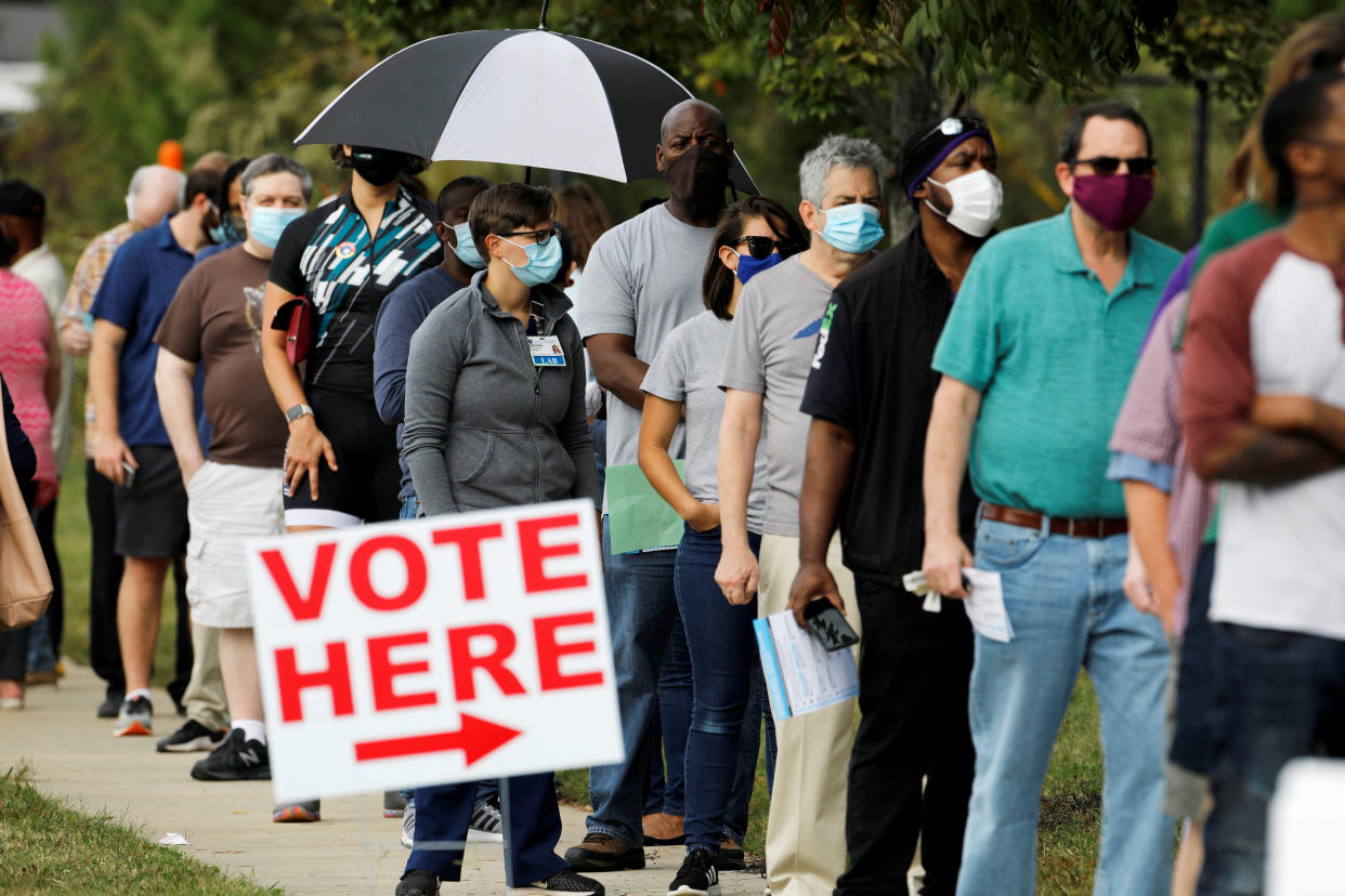 Voters wait in line outside a polling place in Durham, N.C.
