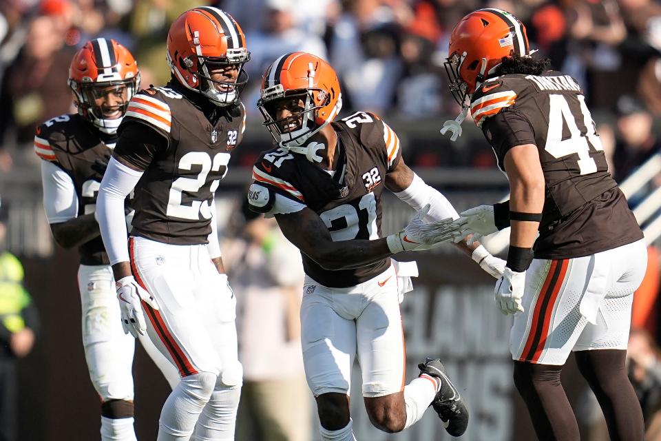 Cleveland Browns cornerback Denzel Ward (21) is congratulated by cornerback safety Grant Delpit, left, cornerback Martin Emerson Jr. (23) and linebacker Sione Takitaki (44) after intercepting a pass against the Arizona Cardinals on Sunday in Cleveland.