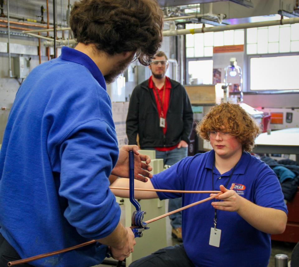 Diman Regional Vocational Technical High School students Connor Kennedy and Paul Hart bend a length of copper pipe in the HVAC shop, while instructor Wyatt L'Etoile watches them on Thursday, Feb. 29.