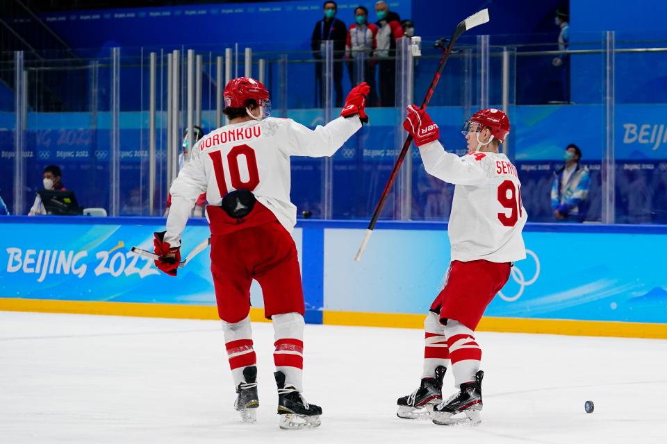 Russian Olympic Committee's Kirill Semyonov (94) celebrates with Dmitri Voronkov (10) after Krill scored an open net goal against Denmark during a preliminary round men's hockey game at the 2022 Winter Olympics, Friday, Feb. 11, 2022, in Beijing. (AP Photo/Matt Slocum)