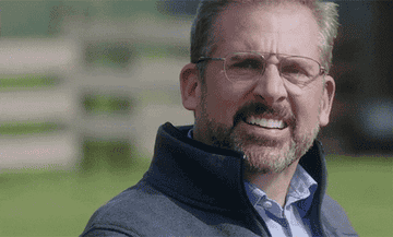 Man with beard smiling outdoors, in a navy jacket over a blue shirt. Relevant to parenting themes