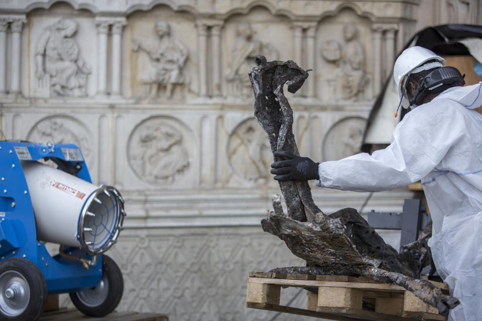 A worker cleans debris, during preliminary work to repair the fire damage at the Notre-Dame de Paris Cathedral, in Paris, France, Wednesday, July 24, 2019. (AP Photo/Rafael Yaghobzadeh, Pool)