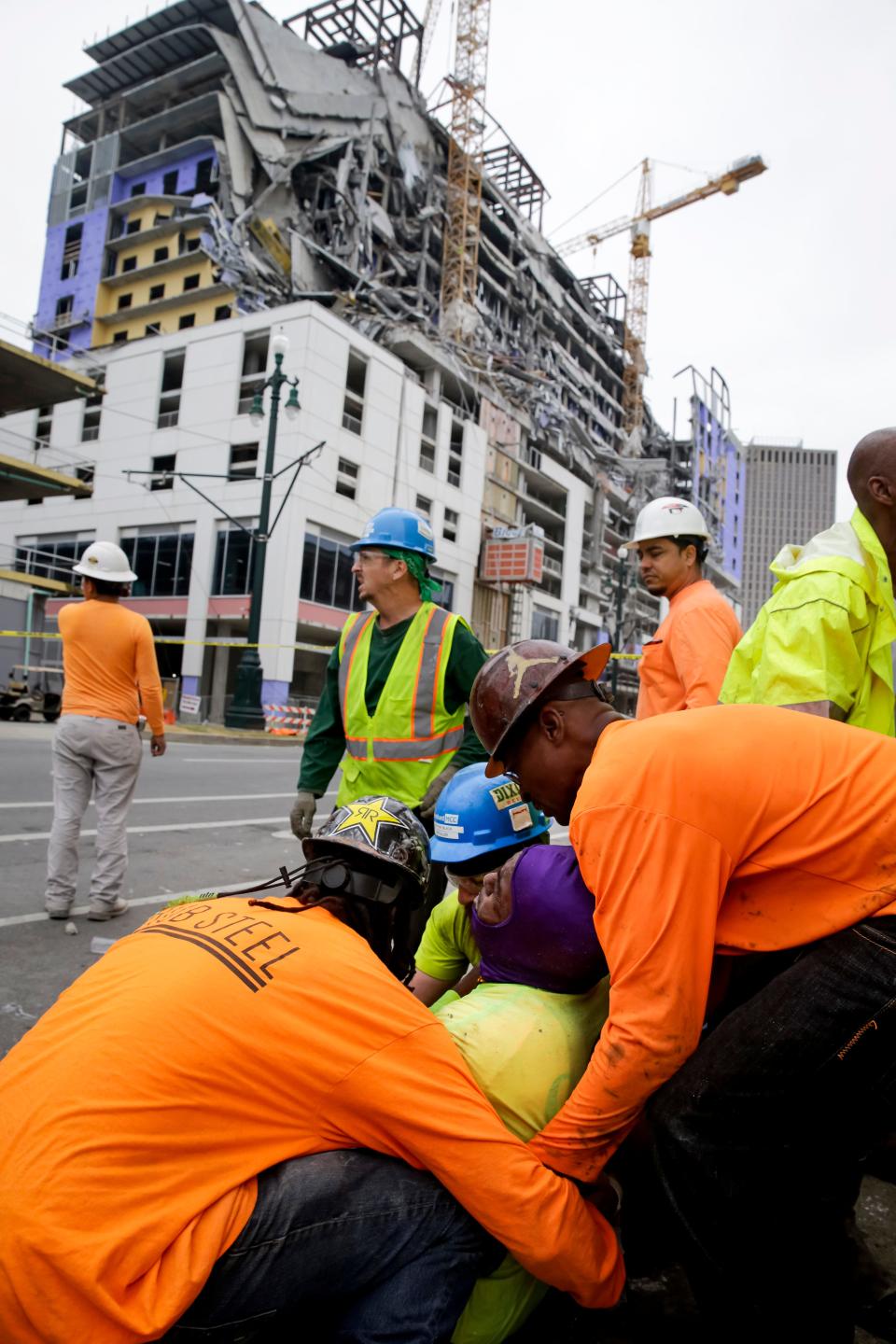 Workers are helped after a large portion of the under-construction Hard Rock Hotel suddenly collapsed in New Orleans on Saturday.