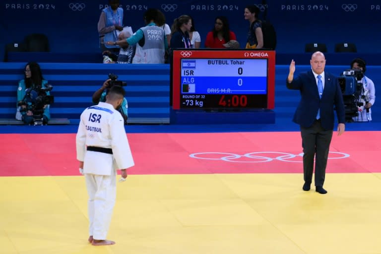 El judoca israelí Tohar Butbul saluda al árbitro español Raúl Camacho ante la ausencia de su rival, el argelino Messaoud Dris, en la categoría de 73 kilos en los Juegos Olímpicos de París-2024, en el estadio Campo de Marte, el 29 de julio de 2024. (Luis ROBAYO)