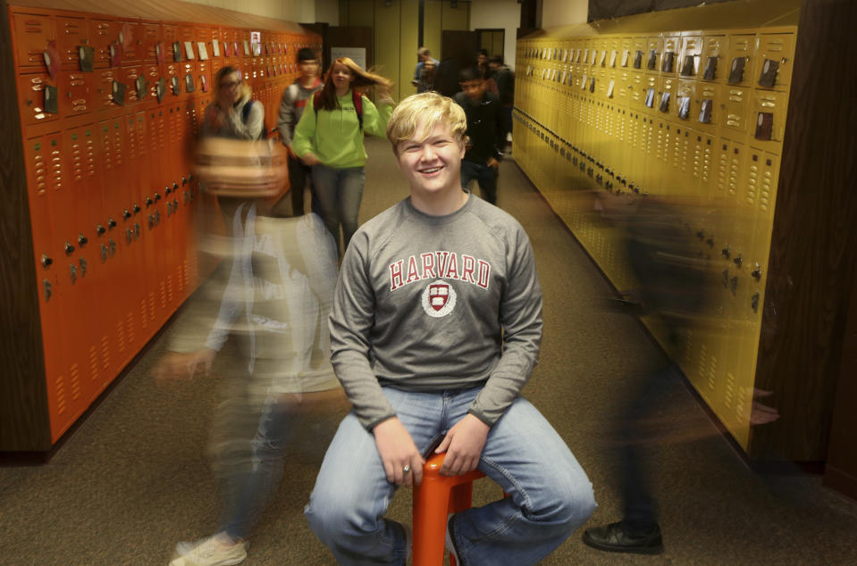 Ulysses High School senior Braxton Moral sits for a portrait at the school in Ulysses, Kan., on Wednesday, Dec. 12, 2018. The 16-year old said his fellow students at the high school often treat him just like any other student, although they do like to tease him about his expected graduation from Harvard University a few weeks before he graduates from high school. Moral works on his Harvard studies three hours each day at high school. He also participates in other school activities such as weights, scholars bowl, debate and tennis. (Sandra J. Milburn/The Hutchinson News via AP)