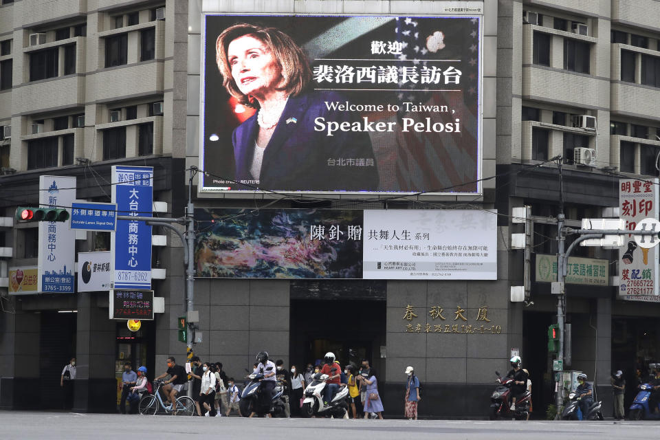 FILE - People walk past a billboard welcoming U.S. House Speaker Nancy Pelosi, in Taipei, Taiwan, Aug 3, 2022. Days after Ayman al-Zawahiri was killed in Kabul, China staged large-scale military exercises and threatened to cut off contacts with the U.S. over House Speaker Nancy Pelosi's visit to Taiwan. (AP Photo/Chiang Ying-ying, File)