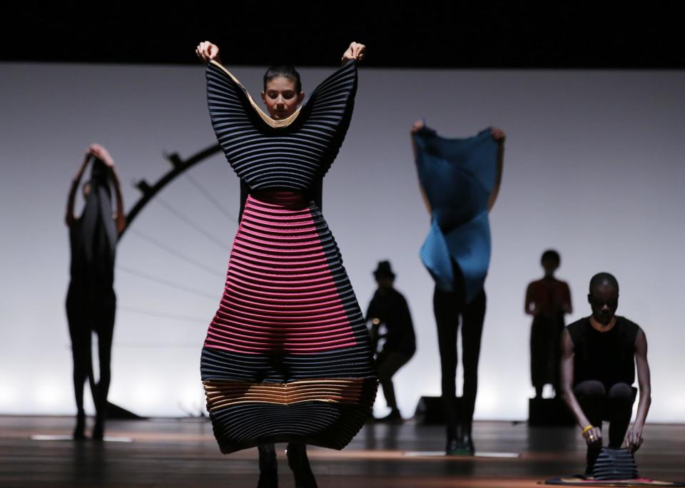 Models get dressed on the catwalk as part of Issey Miyake's ready to wear fall/winter 2014-2015 fashion collection presented in Paris, Friday, Feb.28, 2014. (AP Photo/Jerome Delay)