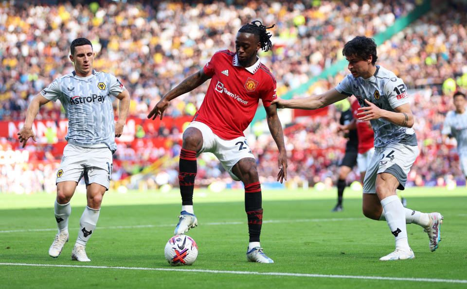 MANCHESTER, ENGLAND - MAY 13: Aaron Wan-Bissaka of Manchester United controls the ball whilst under pressure from Daniel Podence and Hugo Bueno of Wolverhampton Wanderers during the Premier League match between Manchester United and Wolverhampton Wanderers at Old Trafford on May 13, 2023 in Manchester, England.  (Photo by Clive Brunskill/Getty Images)