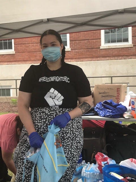 Tiara Gilbert, a member of Freedom Fighters DC, helped hand out items, including paper towels and water, June 7 in Washington, D.C. The new group has been pushing to defund the police and protesting across the city. (Deborah Barfield Berry, USA TODAY)