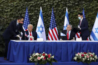 Israeli Prime Minister Benjamin Netanyahu, second right, and U.S. Ambassador to Israel David Friedman, second left, attend a ceremony to sign amendments to a series of scientific cooperation agreements, at Ariel University, in the West Bank settlement of Ariel, Wednesday, Oct. 28, 2020. The United States and Israel amended the agreements on Wednesday to include Israeli institutions in the West Bank, a step that further blurs the status of settlements widely considered illegal under international law. (Emil Salman/Pool via AP)