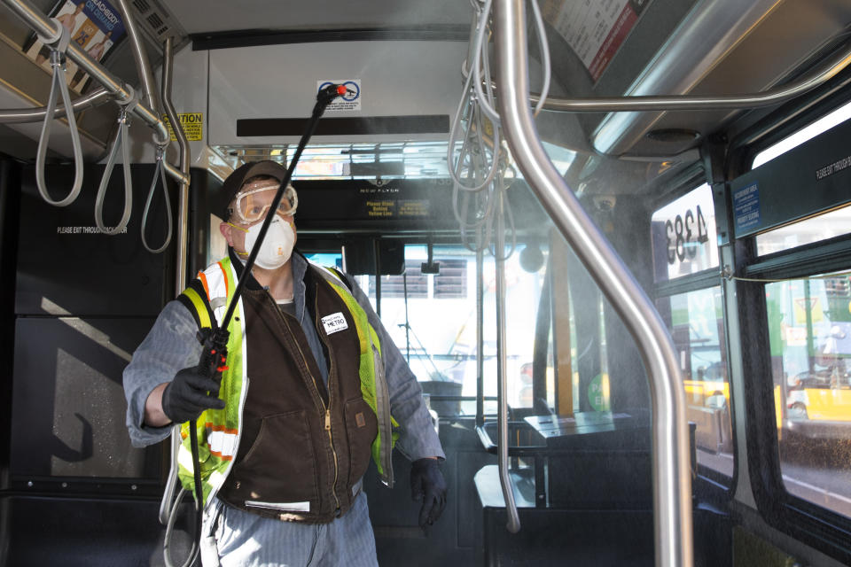 Larry Bowles, an equipment service worker for King County Metro, sprays Virex II 256, a disinfectant, throughout a metro bus at the King County Metro Atlantic/Central operating base in Seattle, Washington. 