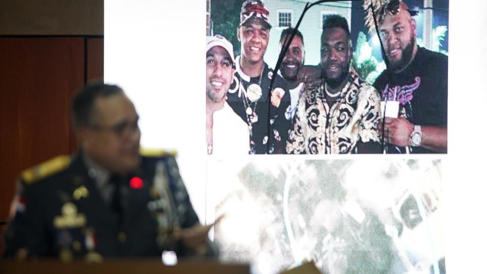 Director of the National Police, General Ney Aldrin Bautista Almonte, projects a photograph taken of former Boston batter David Ortiz, second from right, with others on the night he was shot in Santo Domingo, Dominican Republic, Wednesday June 19, 2019. According to Bautista Almonte, Ortiz was shot by a gunman who mistook him for the real target, Sixto David Fernández, not in the projected photo, who was seated at the same table with the former baseball star on the night of June 9. (AP Photo/Roberto Guzman)