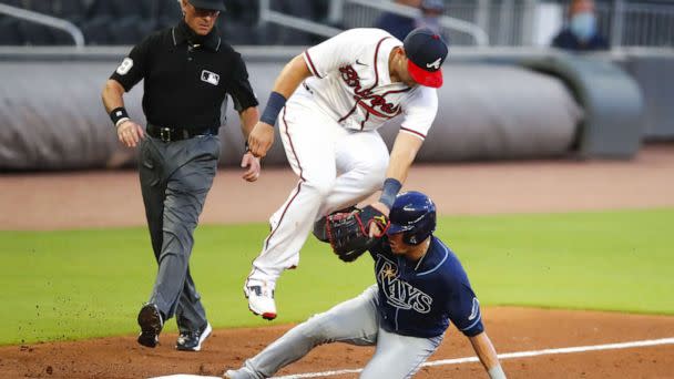 PHOTO: Willy Adames #1 of the Tampa Bay Rays slides under Austin Riley #27 of the Atlanta Braves and rounds third to score on a throwing error in the fifth inning of an MLB game at Truist Park, July 29, 2020, in Atlanta. (Todd Kirkland/Getty Images)