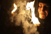 A Christian pilgrim holds candles at the church of the Holy Sepulcher, traditionally believed to be the burial site of Jesus Christ, during the ceremony of the Holy Fire in Jerusalem's Old City, Saturday, April 19, 2014. The "holy fire" was passed among worshippers outside the Church and then taken to the Church of the Nativity in the West Bank town of Bethlehem, where tradition holds Jesus was born, and from there to other Christian communities in Israel and the West Bank. (AP Photo/Dan Balilty)