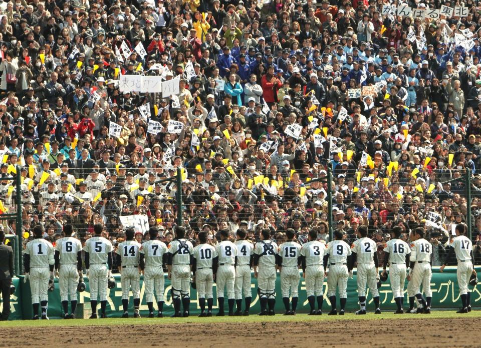 Spectators cheer baseball players of the Tohoku high school at the Koshien Stadium in Nishinomiya, suburban Osaka on March 28, 2011. The baseball team from a high school in Japan's quake and tsunami devastated northeast were the heroes of a hugely popular national tournament, despite losing 7-0.  AFP PHOTO / JIJI PRESS (Photo credit should read JIJI PRESS/AFP/Getty Images)